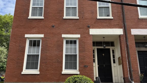 3-Story brick townhouse with side hall entry, flat roof and stone foundation