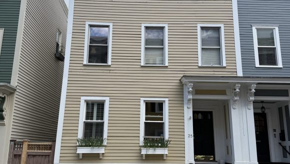 3 story wood clapboard house with side hall entry and flat roof